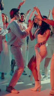 Beyaz Sevgililer Günü kutlamasında romantik çift yakın dans ediyor. Modern markalar için zarif parti estetiği, görsel pazarlama ve şık olay fotoğrafçılığı kavramı.