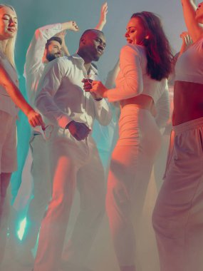 Beyaz partide renkli sahne ışıkları altında dans eden zarif bir çift. Moda estetiği kavramı, etkinlik tanıtımı görselleri, markalaşma ve eğlence kültürü için yaşam tarzı kutlamaları.