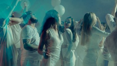 Genç yetişkinler parlak ışıklarla rüya gibi beyaz dans partisinin tadını çıkarıyorlar. Moda ve tarz kavramı, gençlik duyguları ve gece hayatı kutlamaları özgürlük ve neşeyi yakalıyor..