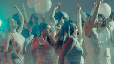 Şık beyaz parti kutlamalarında enerjik kadınlar neşeyle dans ediyor. Moda ve hareket yoluyla modern yaşam tarzı, özgürlük ve duygusal ifade kavramı.