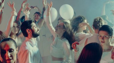 Parlayan beyaz sevgililer günü ışığında gülümseyen kalabalık birlikte dans ediyor. Sosyal kutlama kavramı, duygusal birlik ve mutluluğun gençlik ifadesi..