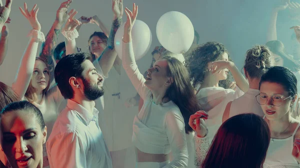 Parlayan beyaz sevgililer günü ışığında gülümseyen kalabalık birlikte dans ediyor. Sosyal kutlama kavramı, duygusal birlik ve mutluluğun gençlik ifadesi..