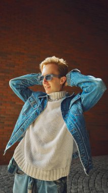 Kot ceketli gülümseyen adam rahat bir şekilde güneş ışığının tadını çıkarıyor. Sosyal medya yaşam tarzı kavramı, refah psikolojisi, eğitim kursları, nüfuzlu markalaşma.