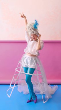 Korse ve mavi taytlı dans eden rococo kadın renkli arka planda neşe ifade ediyor. Moda editörlüğü, sosyal medya kampanyası, performans sanatı eğitimi ve yaşam tarzı markalaşması kavramı.