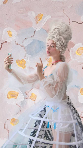 Rococo 'lu kadın çiçekçide akıllı telefonuyla selfie hareketi yapıyor. Lüks medya kampanyası, parfüm hikaye anlatımı ve gençlik zarafetiyle markalaşma kavramı..