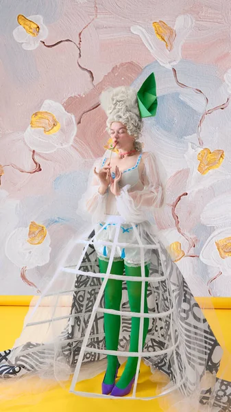 Korseli Rococo kadın yeşil taytlı Marie Antoinette elinde çiçeklerle renkli lolipop tutuyor. İçecek ve şekerleme markası kavramı, moda editörü ve neşeli kadınlık..