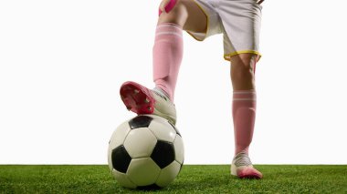 Ayakları topun üzerinde duran kadın futbolcu güç ve kontrol gösteriyor. Spor reklamcılığı, spor kıyafetleri tanıtımı, eğitim platformları ve editoryal yayıncılık kavramı..