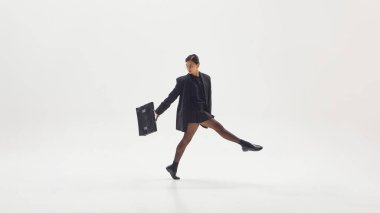 Hareket halindeki iş kadını çantasını dinamik olarak gücü, yaratıcılığı ve profesyonel enerjiyi sembolize ediyor. Gelecekteki çalışma kültüründe yenilik, liderlik ve hareket kavramı.