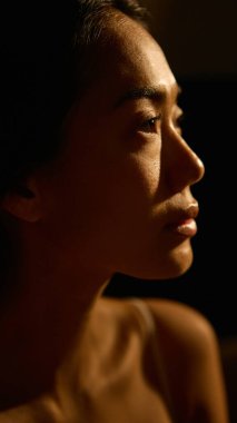 Sıcak ışıktaki kadın portresi duygusal derinlik ve dinginlik gösteriyor. İçsel refahla bağlantılı öz yansıma, duygusal farkındalık ve kişisel sakinlik kavramı.