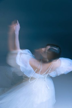 Dalgalı tüller içinde yukarı doğru hareket eden bir dansçı jesti. İnciler hareket halinde parıldıyor. Çağdaş bale kavramı, parfüm hikaye anlatımı, ve zarif iç tasvirler..