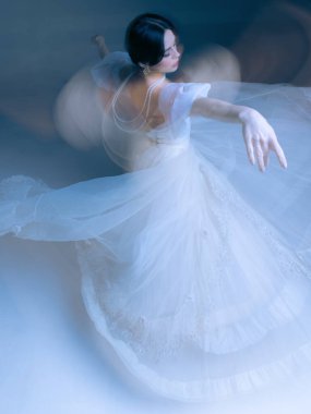 Beyaz elbiseli dansçı. Kollarını uzatıyor. Etrafı parlak hareket bulanıklığıyla çevrili. Moda zerafeti, parfüm kampanyası görselleri, akışkan hareket ve danstaki farkındalık kavramı.