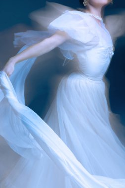 Hareketli beyaz ipek elbise, akışkan zarafet ve altın ışıkla uzatılmış kol. Parfüm markalaşması, hareket terapisi ve ihtiyatlı duruşu olan çağdaş dekor kavramı..