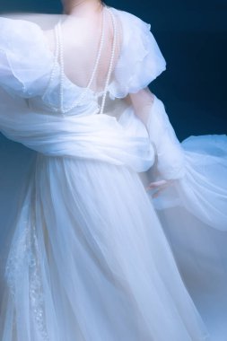 Yumuşak hareket eden kumaş ve inci teller, yumuşak ışık ve zarafet. Aksesuar tasarımı, duygusal sakinlik ve görsel hareketlerdeki moda zarafeti kavramı.