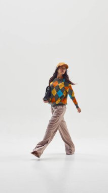 Kendine güvenen renkli kazaklı şık bir kadın, yaratıcılığı ve modern yaşam tarzını temsil ediyor. Moda ve işte bireysellik, dijital göçebeler ve cinsiyet farklılığı kavramı.