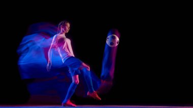 Futbolcu renkli hareketlerle top kontrol tekmesi atıyor. Futbol tekniği eğitimi, atletik hareket tasarımı, spor giyim promosyonu ve yaratıcı reklam görselleri kavramı..