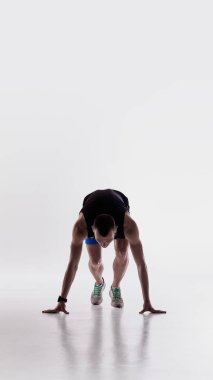 Koşucu öne çömelmiş, koşuya hazırlanıyor. Atletik ısınma öğretim araçları kavramı, hareketlilik hazırlık kılavuzları, koşullandırma programı varlıkları ve koç gösterileri.