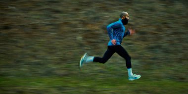 Sporcu, yüksek hızda aşağıya doğru hareket bulanıklığı ile tüm adımlarını atıyor. Patlayıcı kardiyo kavramı, adım verimliliği, açık hava performansı, odaklanmış hareket, güç gelişimi, hızlı eğitim.