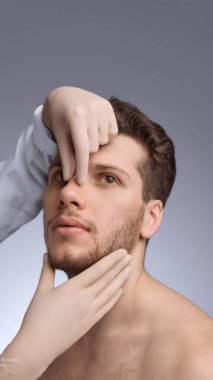 Doktor yüz değerlendirmesi sırasında erkek burun yapısını inceliyor. Burun estetiği eğitimi materyalleri, klinik tanıtımı, anatomi haritası ve görsel düzeltme..