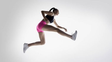 Koşu talimi sırasında güçlü atlama adımlarıyla yakalanan bayan sporcu. Koşu antrenmanları, spor eğitimi, fitness dersleri, hareket analizi ve atletik koşullanma kavramı.