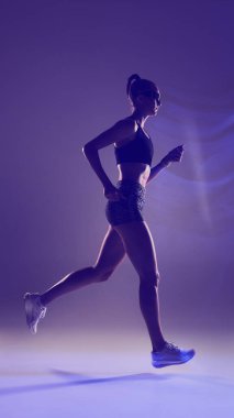 Fütürist enerjisiyle canlı neon ışığı altında koşan kadın sporcu. Modern spor görselleri, fitness reklamları, teknolojik çalışmalar, performans markalaşması ve dinamik yaşam tarzı tasarımı kavramı.