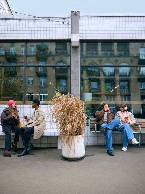 Çağdaş kış kafesinin dışında sıcak içeceklerle rahatlayan gruplar. Etkinlik endüstrisi posterleri, yaşam tarzı blogcularının görselleri, finansal samimi kış kampanyaları ve modern kahve dükkanlarının markalaşması kavramı.