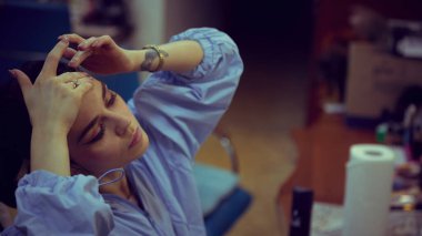 Balerin sahne ayininden önce soyunma odasında saç hazırlıyor. Bakım, hassas stil, tiyatro hazırlığı, sahne rutini, performansla ilgili görseller için güzellik işi akışı kavramı.