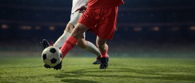 Topun yanındaki rakip oyuncular arasında agresif bir futbol müsabakası. Yüksek bahisli rekabet kavramı, zafer mücadelesi, profesyonel atletizm, rekabet gerilimi, maç yoğunluğu.