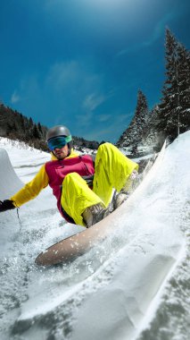 Dağlarda kavisli kar duvarı süren son moda bir snowboardcu. Ekipman performansı, yönetim kurulu kontrolü ve ekipman reklamları, ürün tanıtımı ve marka pazarlama için kış vites güvenilirliği kavramı.