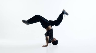 Breakdance kol dengesi donuyor ve dinamik beden kontrolü beyaz arka planda izole ediliyor. Spor markalaşması, hareket ustalığı hikaye anlatımı ve yaratıcı editör görselleri kavramı.