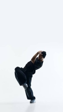 Dans antrenmanı sırasında tek ayak üstünde dengede duran erkek dansçı. Atletik eğitim görselleri, fitness uygulaması içeriği, beden kontrolü eğitimi ve spor giyim pazarlaması kavramı.