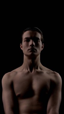 Koyu arkaplanda erkek gövdesi portresi ve çarpıcı bir cilt ışıklandırması. Vücut derisi kavramı, deri dokusu farkındalığı, modern erkeklik, sağIık dengesi ve kaliteli kişisel bakım görselleri..