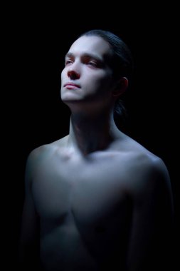 Hafifçe aydınlatılmış çeneli bir erkek portresi. Güven kavramı markalaşma, estetik tıp görselleri, kişisel algılama temaları ve modern sağlık hizmetleri iletişimi.