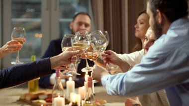 Yemekte şarap kadehiyle grup tost yapıyor. Kutlama pazarlaması, şarap tanıtımı, konukseverlik reklamı, sosyal yaşam tarzı görselleri ve etkinlik markalaşması kavramı.