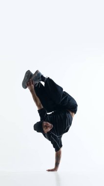Breakdance akrobatik dondurucu ve beyaz stüdyo arka planında izole edilmiş bacakları var. Yaratıcı spor kampanyaları, hareket ustalığı görsellik ve modern fitness markalaşması kavramı.