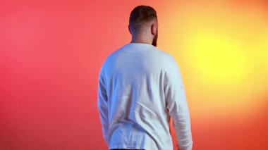 Sakallı adam rotasyonun ortasında rengarenk arka planda güvenle duruyor. Kişisel markalaşma, yaratıcı ajans görselleri, modern kimlik sunumu ve kendine güvenen karakter anlatımı kavramı