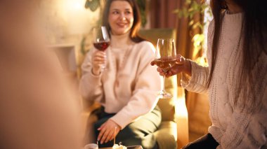 Dostlar sıcak oturma odasında şarap tadarken eğleniyorlar. Evde toplanma, günlük konukseverlik, içecek kültürü, sosyal iletişim, özel parti ve evde rahat bir akşam..