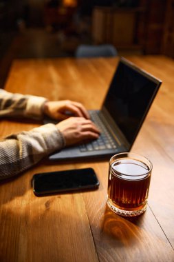 Eller dizüstü bilgisayarda kahve bardağı ve masa başında akıllı telefon ile yazıyor. Kafe dijital markalaşma, içecek tanıtımı, uzak çalışma rutini, verimlilik ve çevrimiçi pazarlama görselleri kavramı.