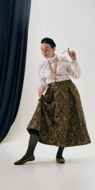 Dantelli bluz giymiş olgun bir kadın ve oyuncu odaklı etek kaldırma eteği. Ayakkabı sunumu, kıyafet ayrıntıları, ayakkabı gösterimi, moda stili, yaşam tarzı ve reklam kullanımı kavramı.