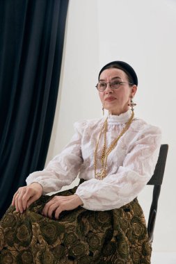 Klasik modaya uygun, oturaklı ve zarif ifadeli bir portre. Zarafet kavramı, eski moda tarzı, sofistike ruh hali, moda hikaye anlatımı, editör ve yaratıcı projeler..