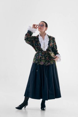Çiçekli ceketli, fırfırlı bluzlu, antika çantalı bir kadın. Şair özgün moda kavramı, romantik klasik tarz, detaylar aracılığıyla kadınlık, editoryal kıyafet estetiği.