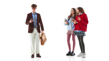 Beyaz liseli kızların yanında telefonu ve çantası olan genç bir çocuk. Gençlik modası, akademik yaşam tarzı, modern gençlik kültürü ve tekrar okul kıyafetleri tarzı..