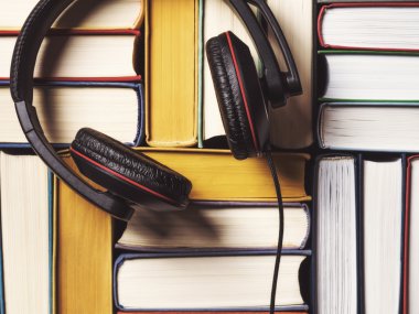 Pile of books with headphones clipart