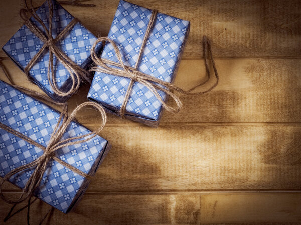 Подарочные коробки из голубой бумаги на деревянном столе

