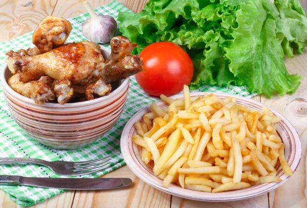 kızarmış tavuk budu, patates ve sebze ahşap bir masa üzerinde