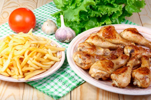 kızarmış tavuk budu, patates ve sebze ahşap bir masa üzerinde