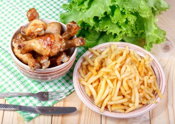 kızarmış tavuk budu, patates ve sebze ahşap bir masa üzerinde