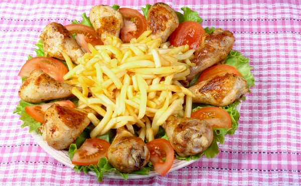 kızarmış tavuk budu, patates ve sebze ahşap bir masa üzerinde