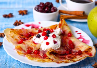 Mavi bir arka plan üzerinde kahvaltı krep ile cherry jam