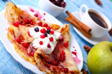Mavi bir arka plan üzerinde kahvaltı krep ile cherry jam