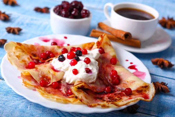 Mavi bir arka plan üzerinde kahvaltı krep ile cherry jam